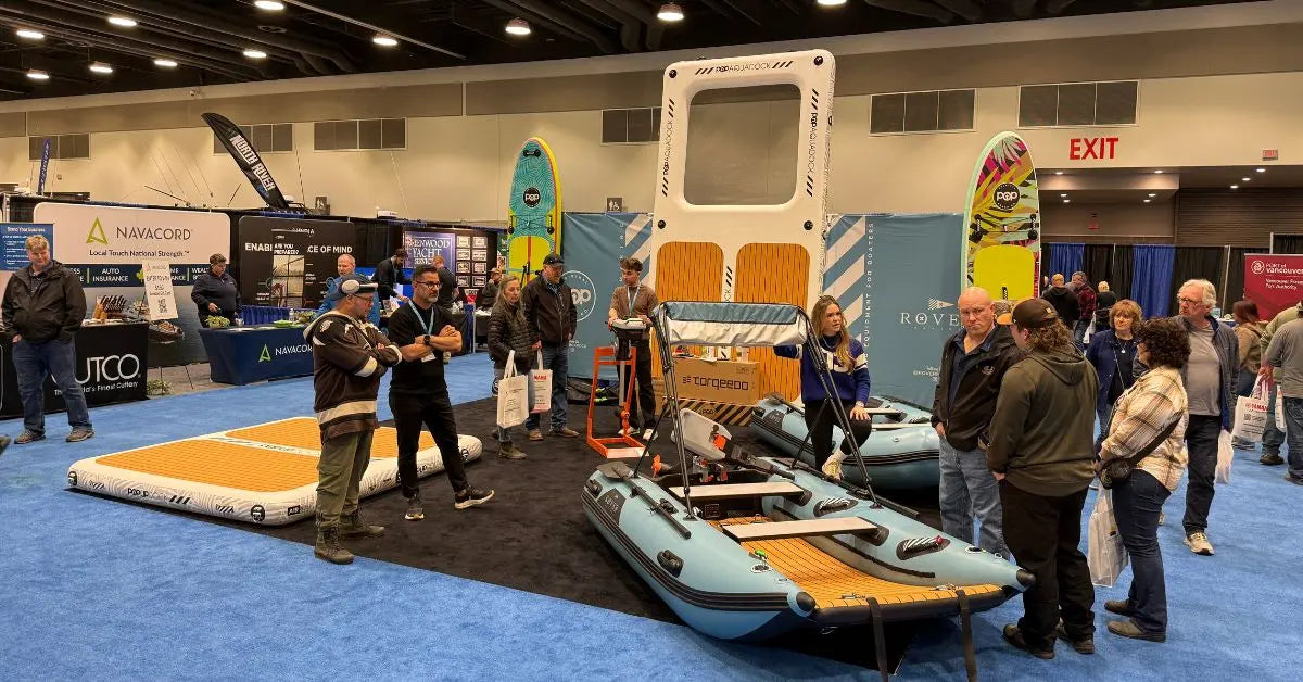 Visitors looking at an inflated POP Board Co dock and a Rover Marine inflatable boat at a Canadian Board Co trade show booth