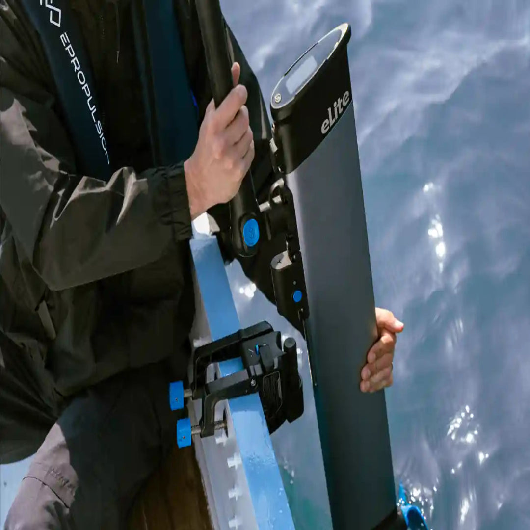 Person holding a black and blue Elite electric motor with water in the background