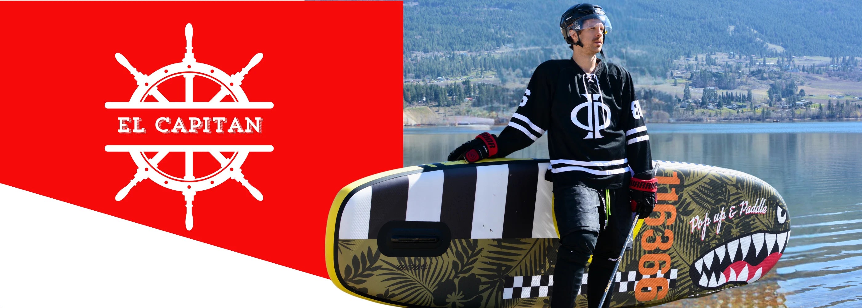 Paddler with El Capitan 11'6 Bomber paddleboard standing lakeside ready for adventure.