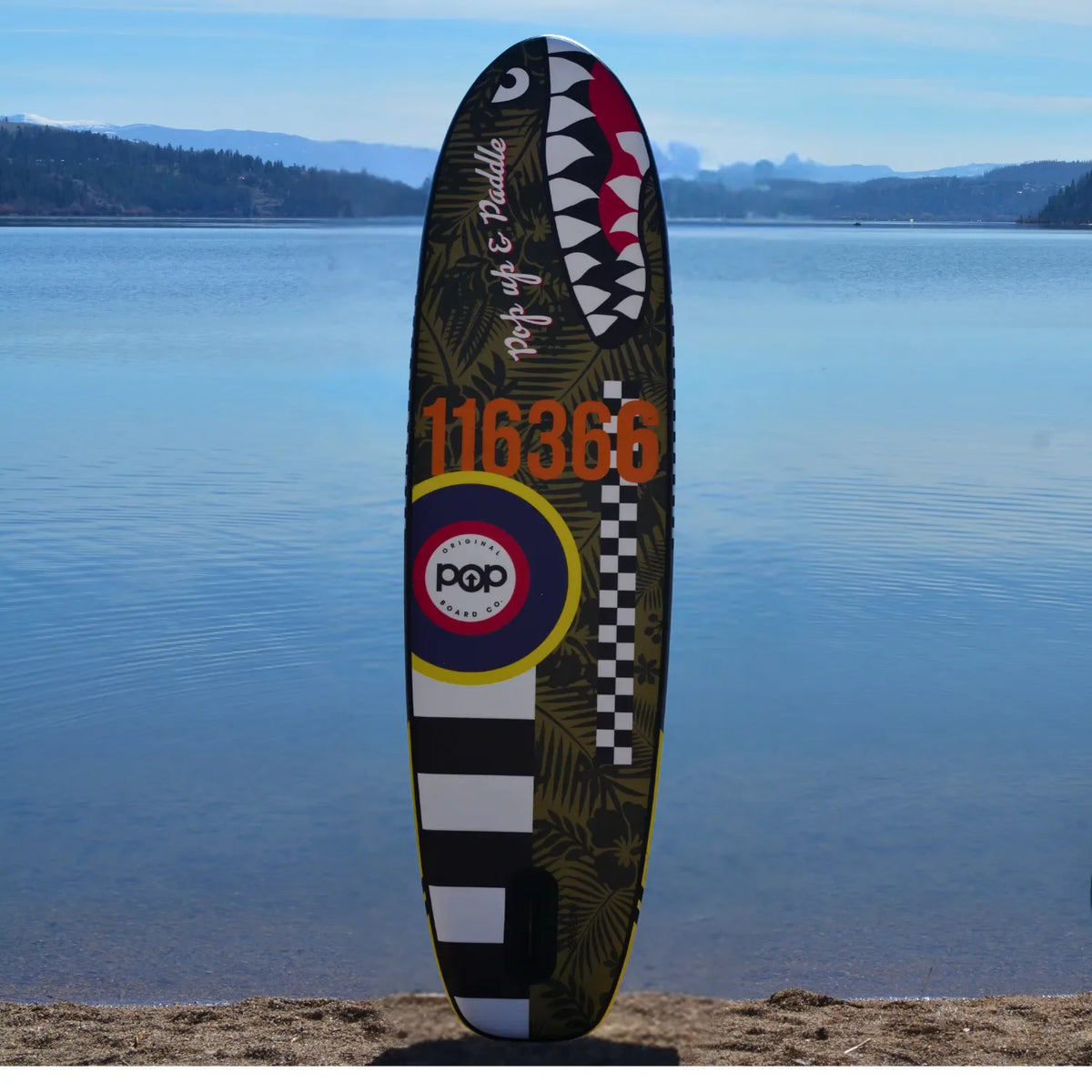 POP Board Co. El Capitan paddleboard with shark mouth and bold 116366 design standing upright by the lake.