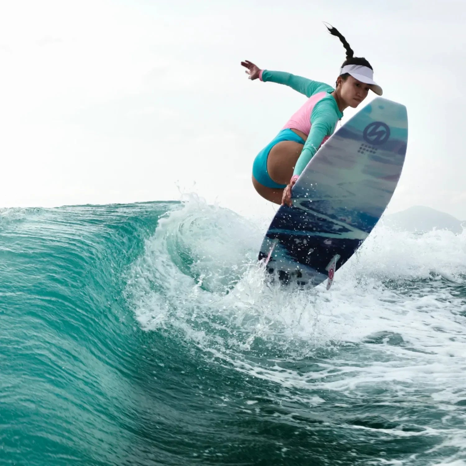 Rider performing a trick on Karen Wang Pro Silver Lining wakesurf board.