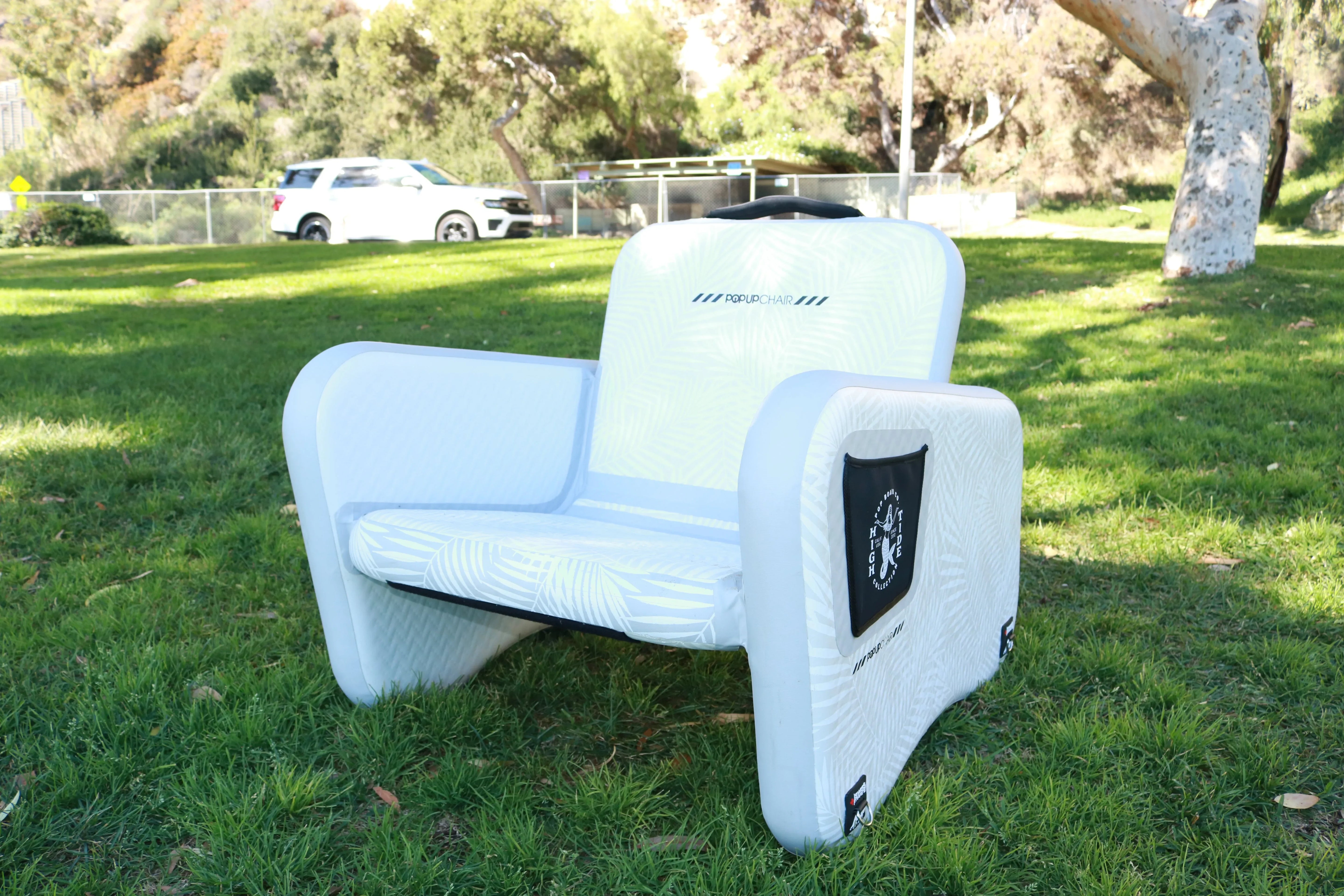 Inflatable POP Up Chair placed on grass, ideal for outdoor, dockside, or lakeside seating.