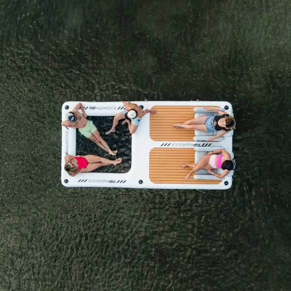 Overhead view of four friends relaxing on a POP Aquadock inflatable floating platform, enjoying time together on the water.