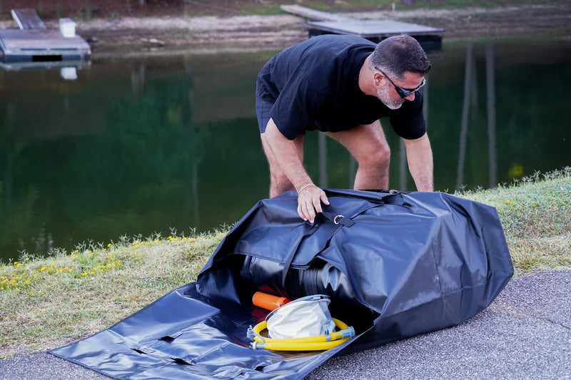 Unpacking the Rover Marine Battle Boat from its bag on the lawn by the lake