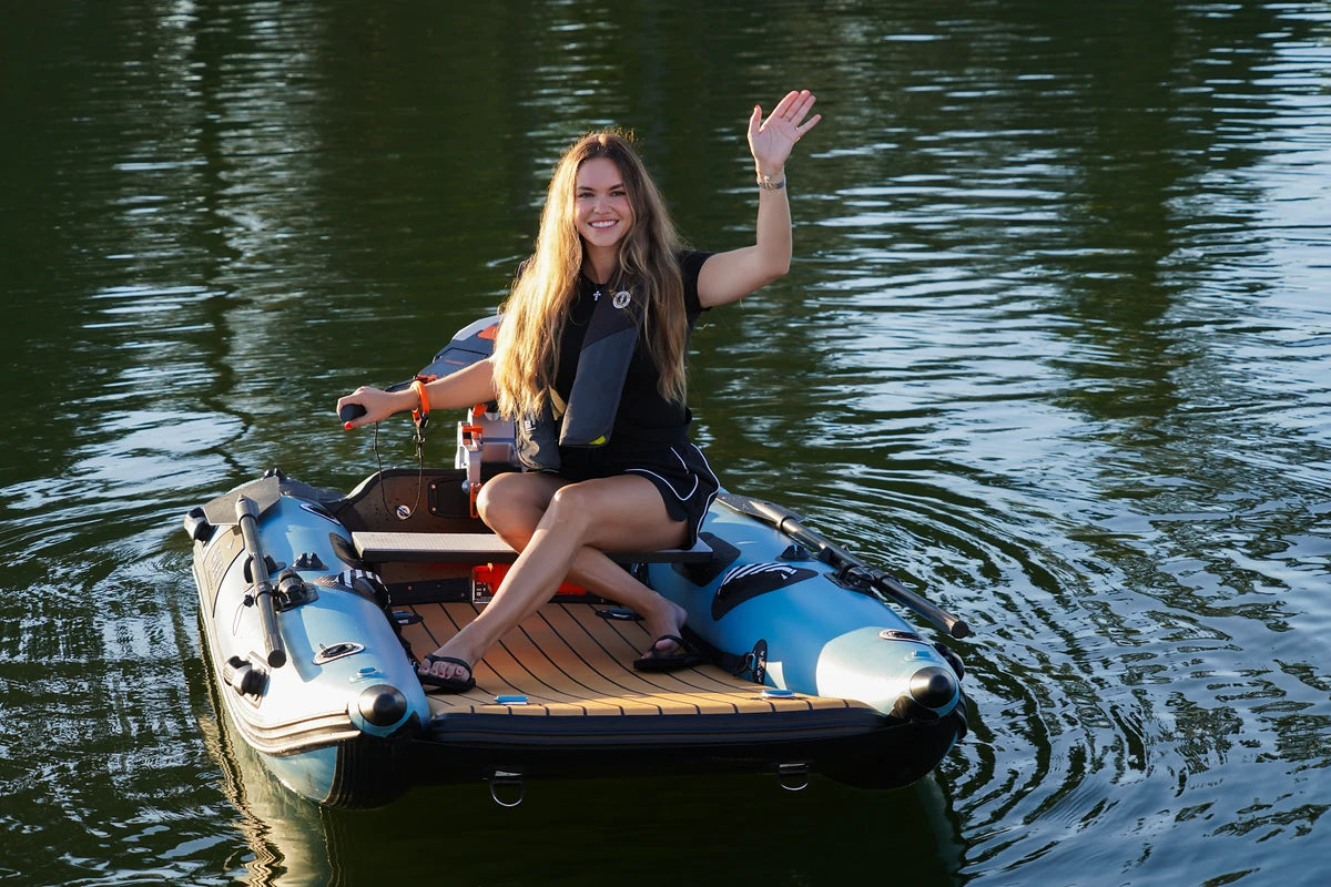 Woman waving from the 8 ft Rover Marine Battle Cat with its teak-look deck