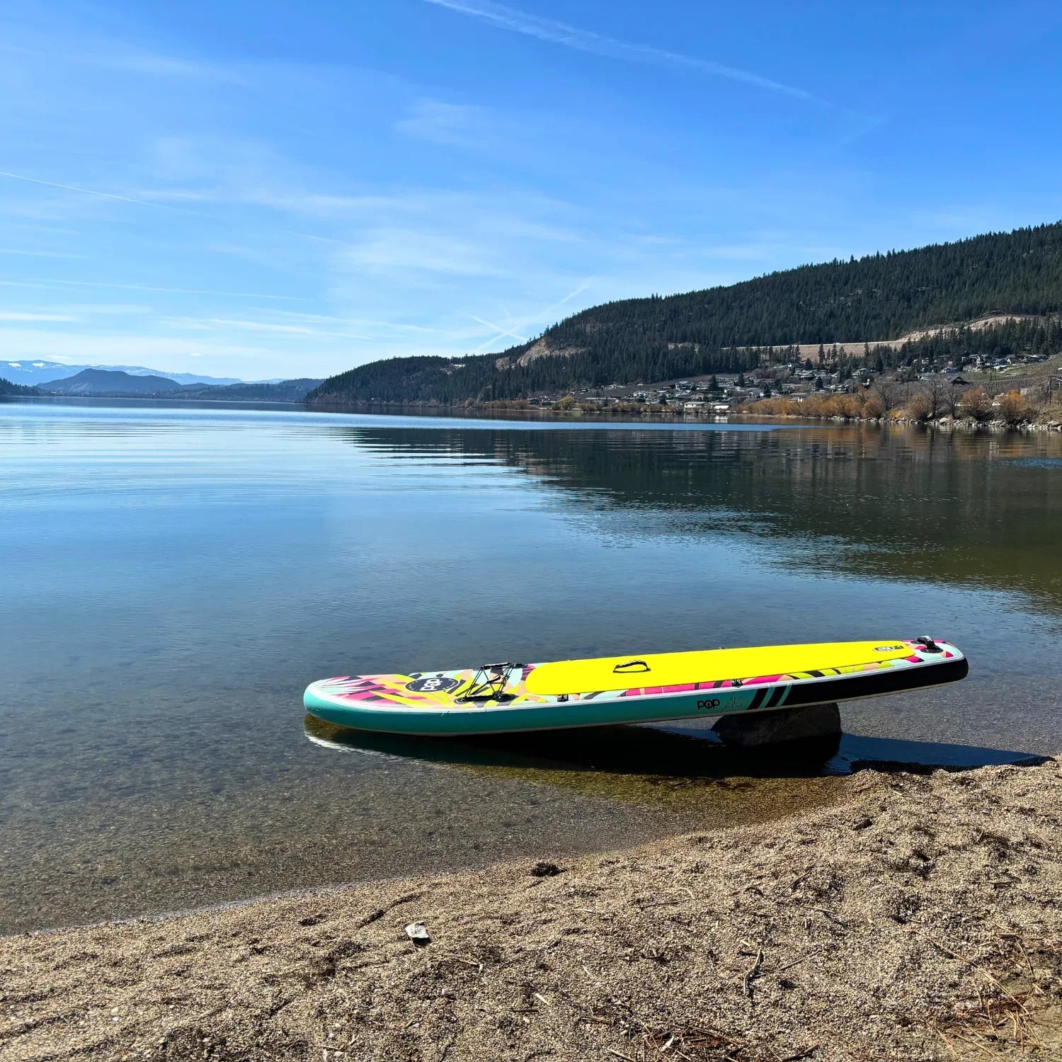 POP Royal Hawaiian 10’6 inflatable paddleboard floating on calm blue water.