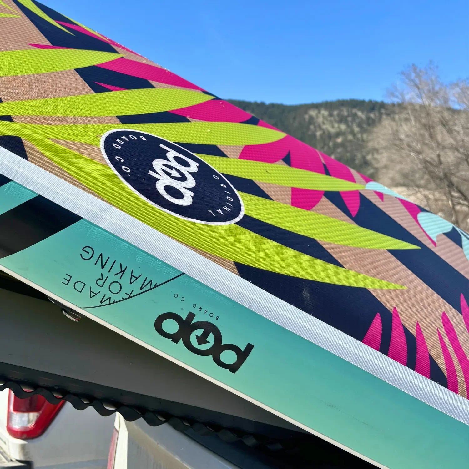 Side view of POP Royal Hawaiian 10’6 inflatable paddleboard 2024 floating on the water.