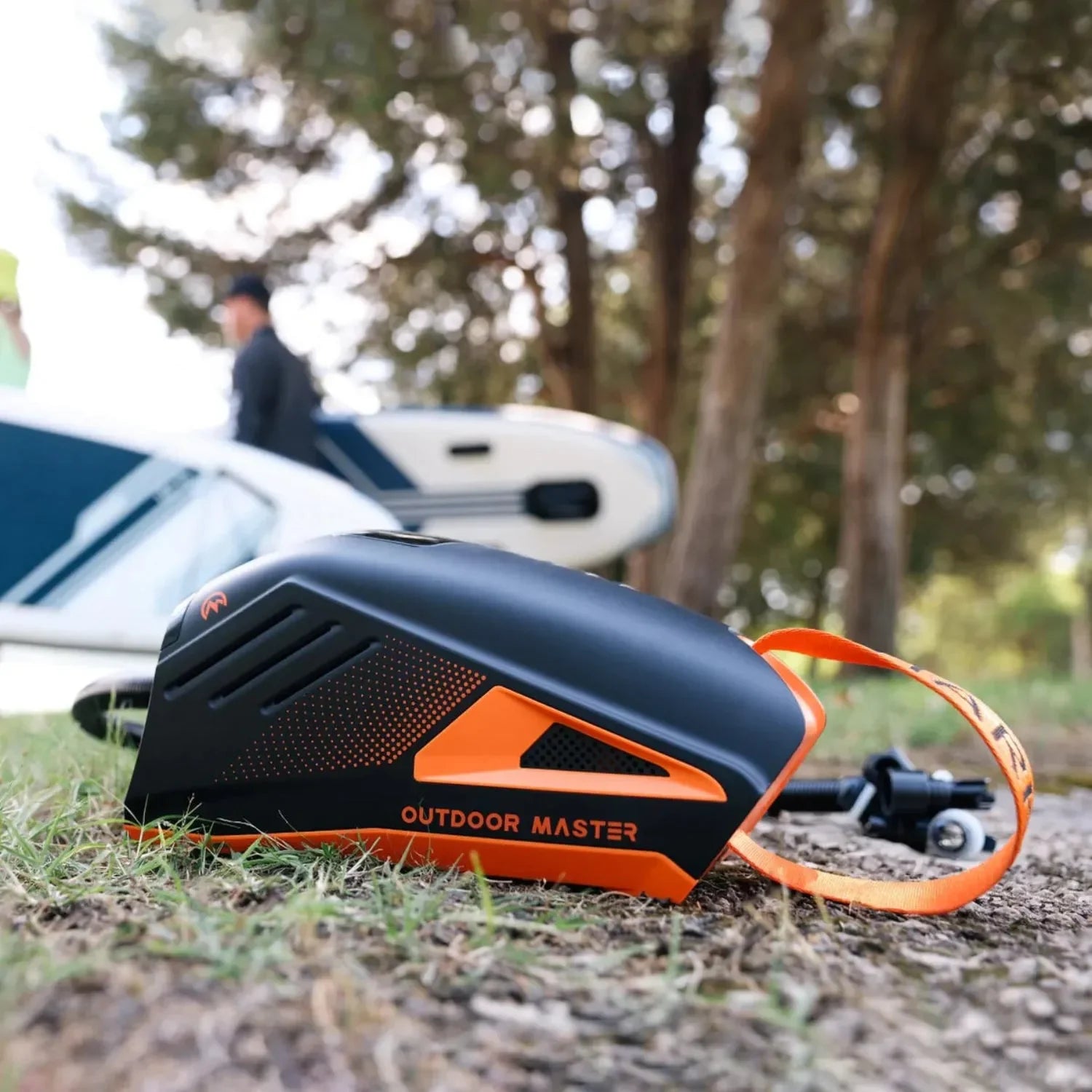 Outdoor Master Shark 3 electric paddle board pump on the ground near inflatable SUPs from Canadian Board Co.
