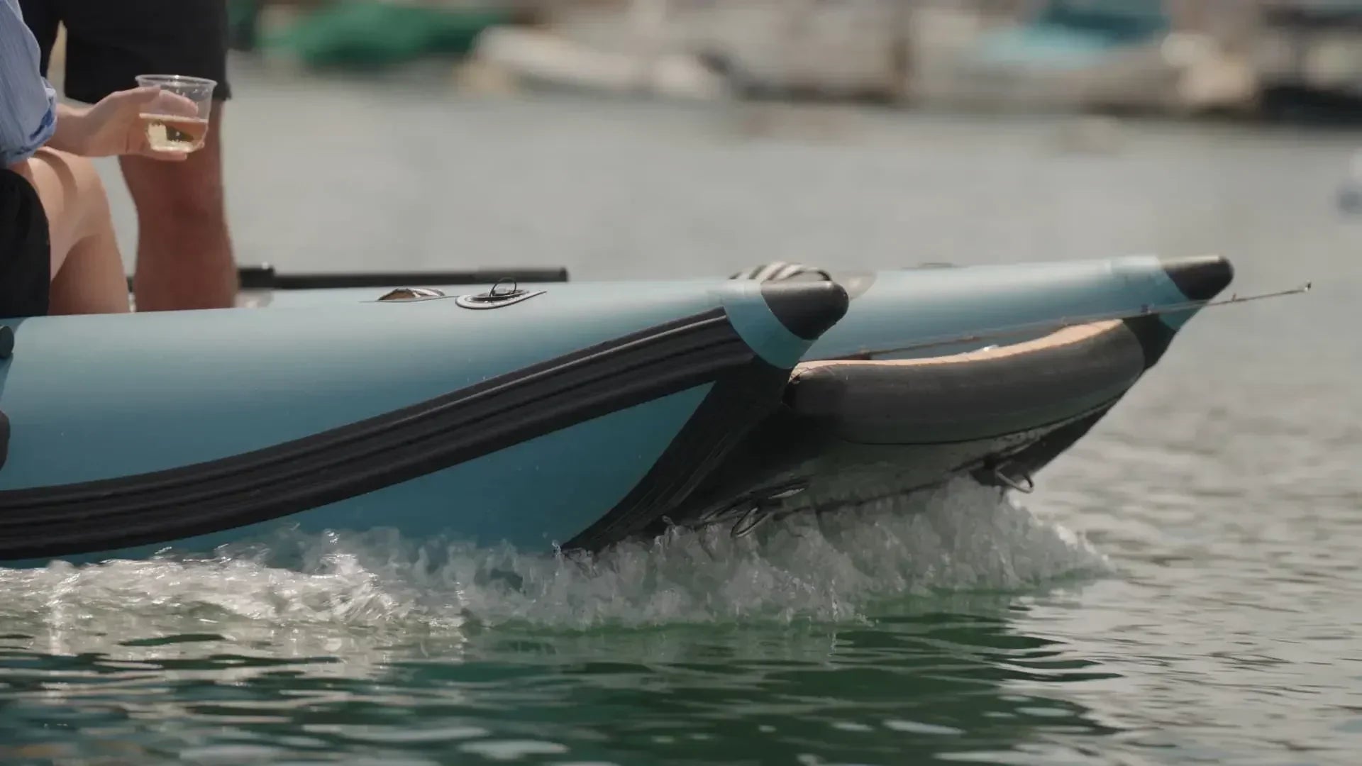 Bow of a Rover Marine inflatable boat cutting through calm marina water.