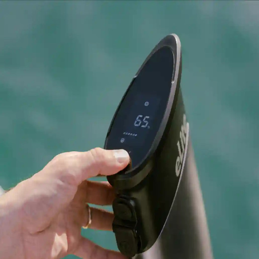 Hand adjusting a digital device on an electric motorvwith water in the background