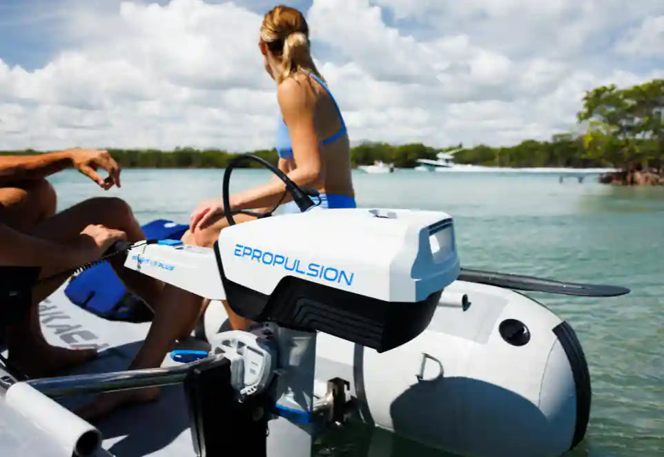 Inflatable boat with Epropulsion system on a body of water, people sitting on it.
