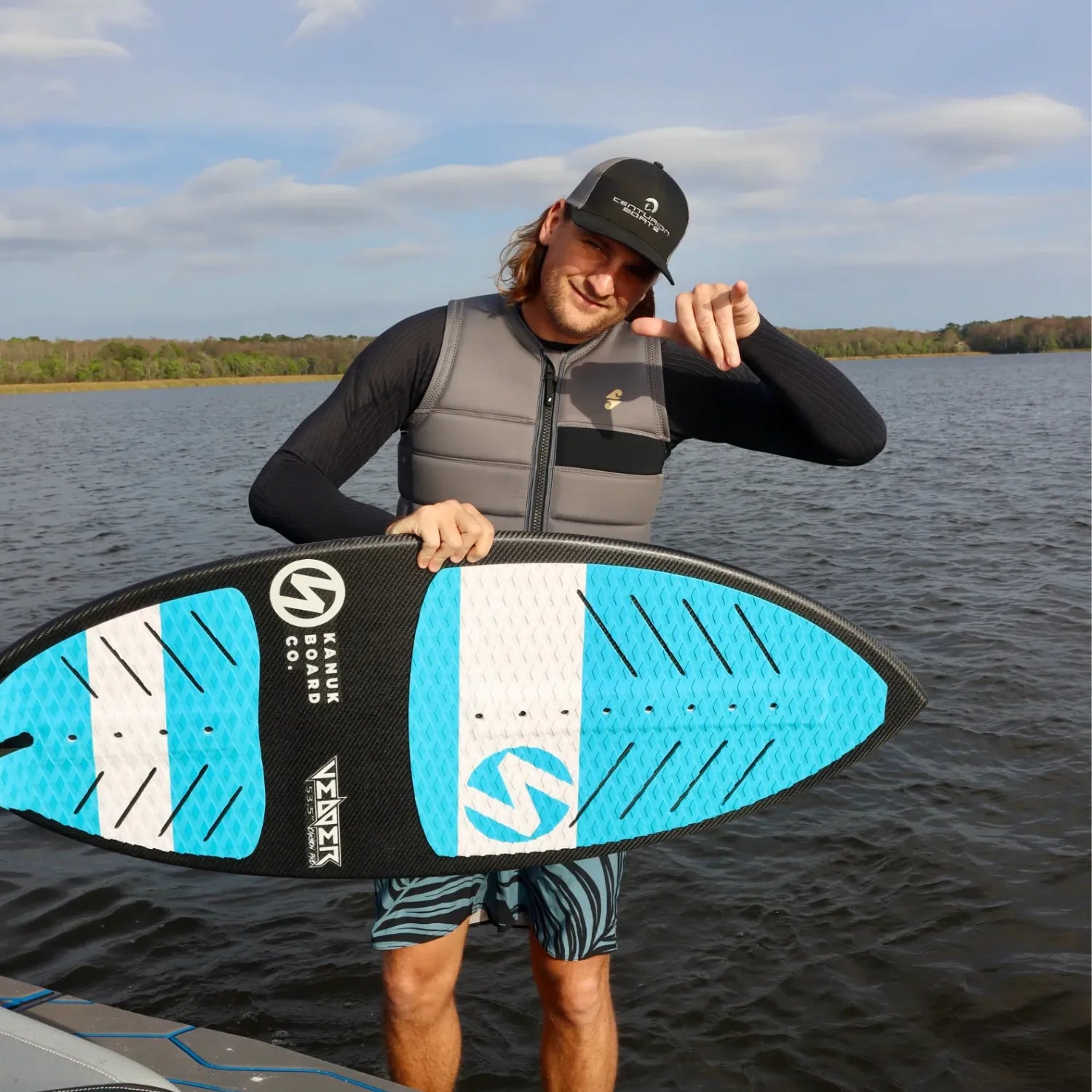 Rider holding Blunt Deese Mode wakeskim board by the water.