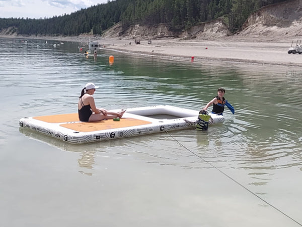 Family using the AquaDock in shallow water off a sandy beach