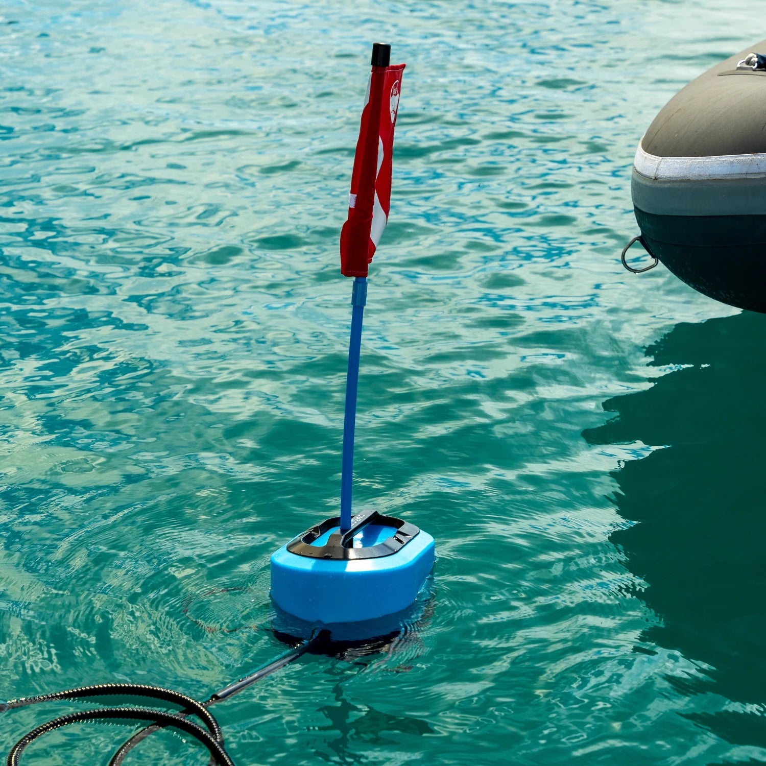 DiveBlu3 Nomad floating battery-powered dive unit with red dive flag in clear blue water.