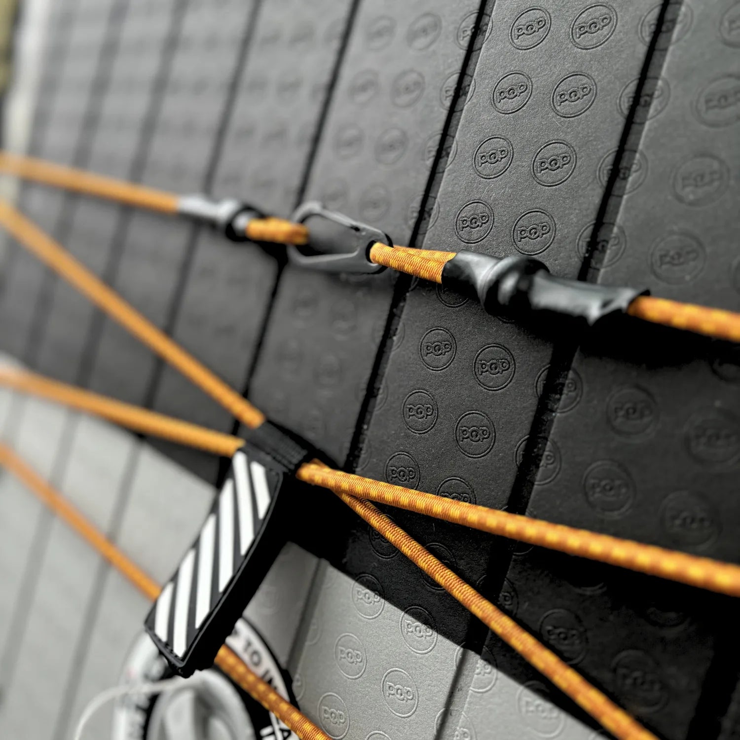 Front bungee storage system on El Capitan 11'6 Bomber paddleboard with orange tie-down cords.