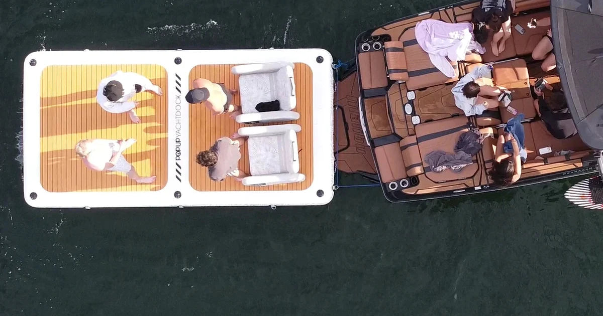 Top-down view of the 14 x 7 ft POP YachtDock tied off behind a wake boat with two POP Up Chairs