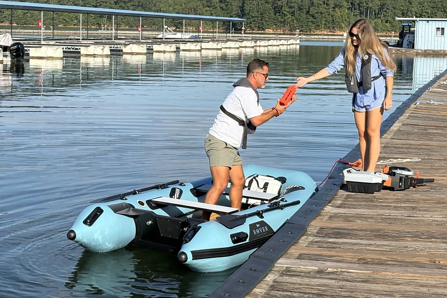 Handing a cooler down from the dock into the 10 ft Rover Marine Battle Boat