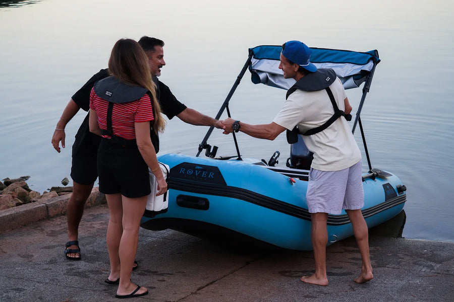 Friends greeting at the boat ramp beside the 12 ft Rover Marine Battle Boat with Bimini