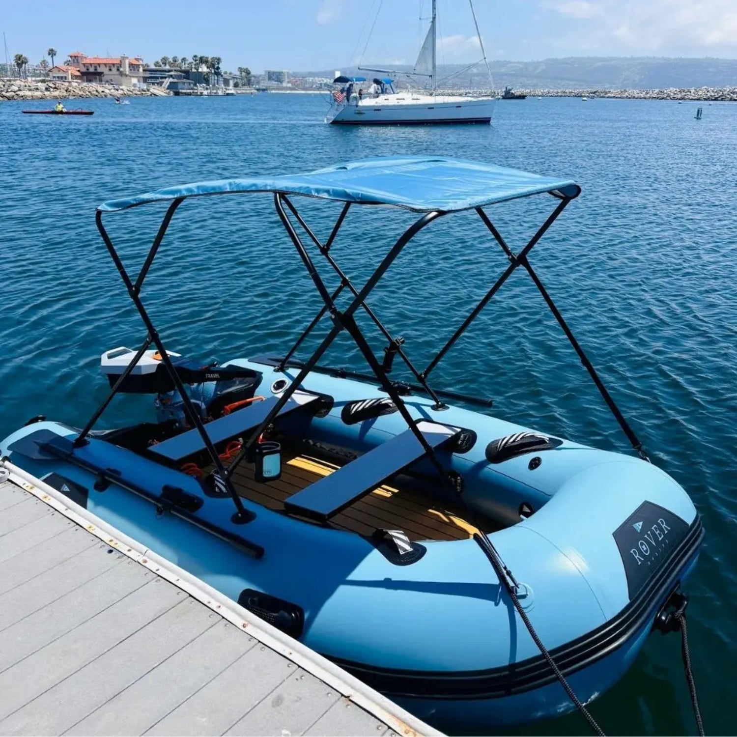 Blue inflatable boat with canopy on a dock by the water