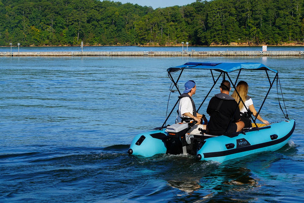 12 ft Rover Marine Battle Cat with a Torqeedo electric outboard cruising past a dock