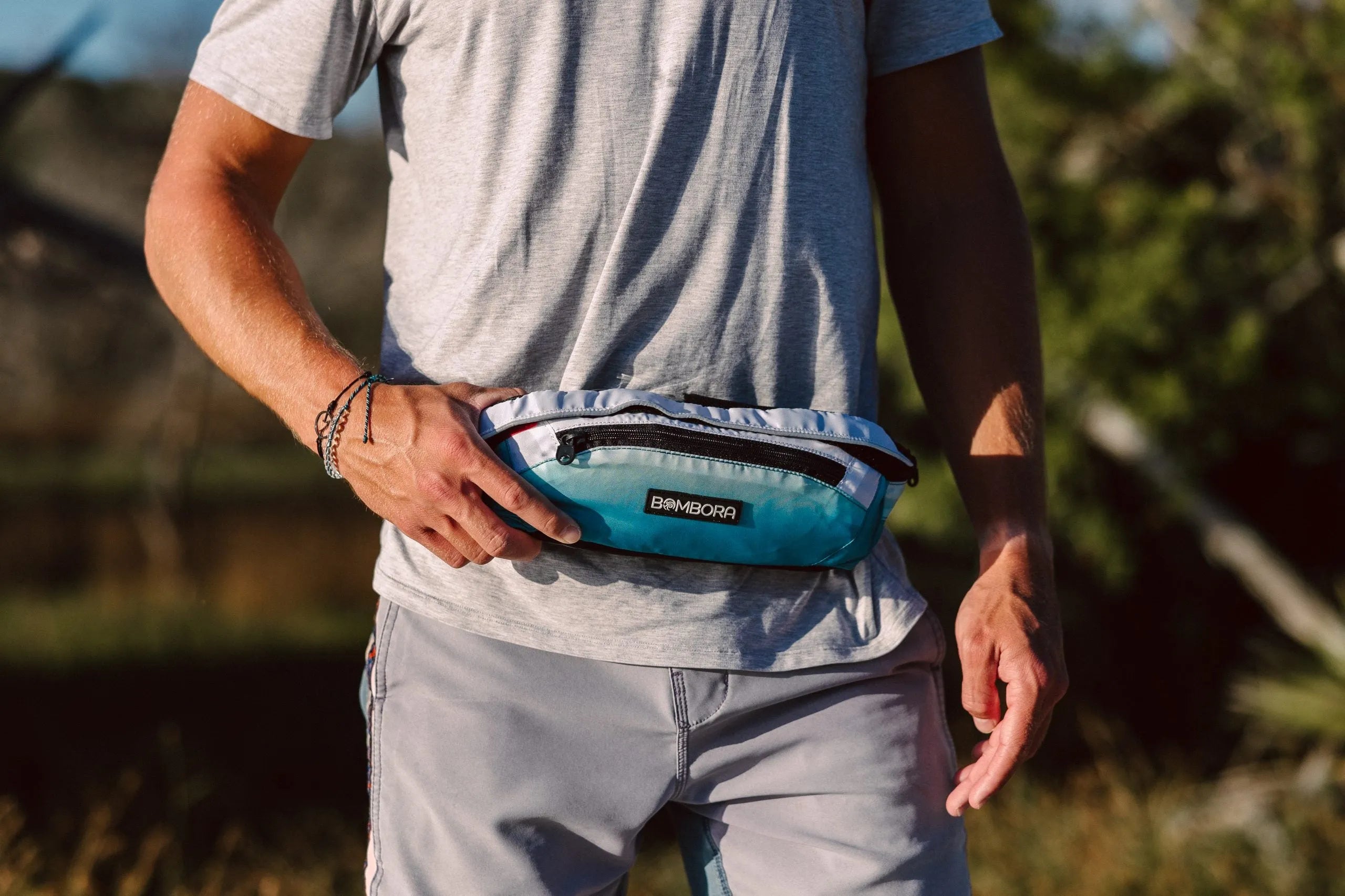 Person wearing the Super Belt inflatable PFD securely around the waist for paddleboarding and water sports.